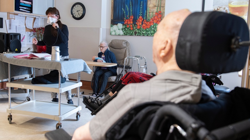 A woman sings for residents at Idola Saint-Jean long-term care home in Laval, Que., on Feb. 25, 2022. (THE CANADIAN PRESS/Graham Hughes)