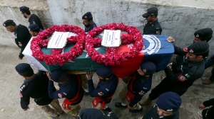 A police contingent carries the casket of a police officer, a victim of Monday's suicide bombing, during his funeral in Peshawar, Pakistan, Feb. 2, 2023. A suicide bomber who killed 101 people at a mosque in northwest Pakistan this week had disguised himself in a police uniform and did not raise suspicion among guards, the provincial police chief said on Thursday. (AP Photo/Muhammad Sajjad)