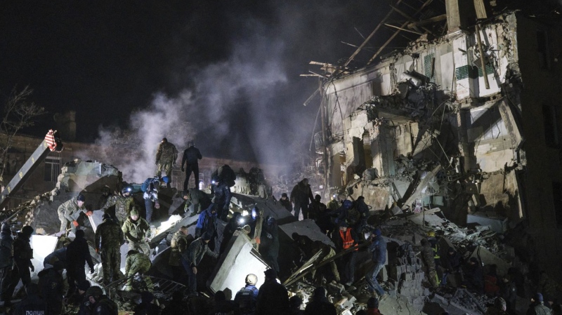Emergency workers and local residents clear the rubble after a Russian rocket hit an apartment building in Kramatorsk, Ukraine, on Thursday, Feb. 2, 2023. (AP Photo/Yevgen Honcharenko)