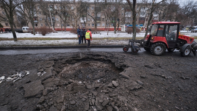 A tractor cleans a road near a crater after a Russian rocket attack in the city center of Kramatorsk, Ukraine, on Feb. 2, 2023. (AP Photo/Yevgen Honcharenko)