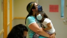 In this file photo, Deni Valenzuela, 2, is held by her mother, Xihuitl Mendoza, in a waiting area of a U.S. health-care centre on June 21, 2022. Ontario doctors are employing an array of strategies, including charging for access to a nurse practitioner, in an effort to deal with demand for primary care amid staffing challenges. (AP Photo/Ted S. Warren)