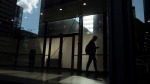 A man walks though a downtown Toronto office building with other buildings reflected in a window in this June 11, 2019 photo. THE CANADIAN PRESS/Graeme Roy