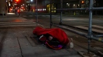 A homeless man sleeps on the street, in Toronto, on Friday, March 11, 2022. THE CANADIAN PRESS/Chris Young 