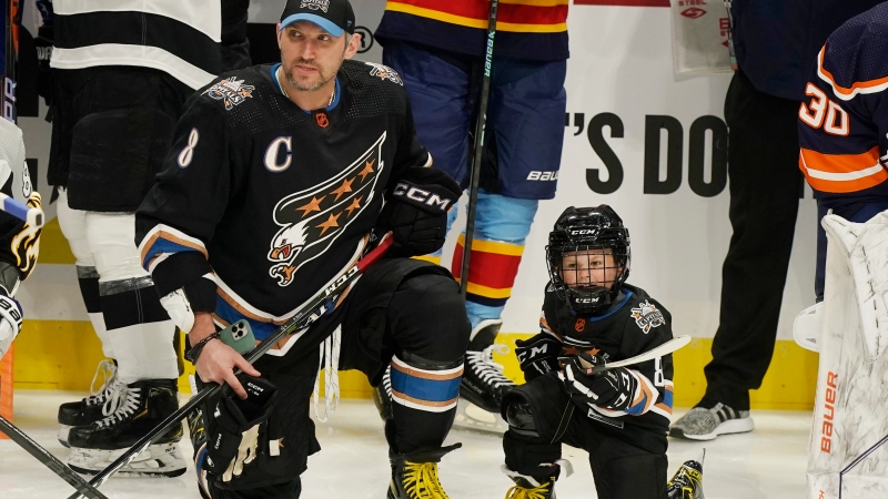 Washington Capitals' Alex Ovechkin (8) and his son waits for the events to start during the NHL All Star Skills Showcase, Friday, Feb. 3, 2023, in Sunrise, Fla. (AP Photo/Marta Lavandier)