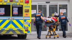 Paramedics transfer a person into a hospital in Montreal, Thursday, July 14, 2022, as the COVID-19 pandemic continues in the province causing an increase in hospitalizations. THE CANADIAN PRESS/Graham Hughes 