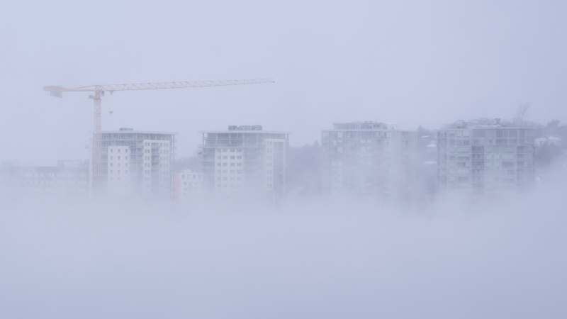 A construction crane is seen through sea smoke in Dartmouth, N.S. on Saturday, February 4, 2023. THE CANADIAN PRESS/Darren Calabrese 
