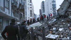 Trying to reach trapped residents inside collapsed buildings in Adana, Turkiye, on Feb. 6, 2023. (IHA agency via AP) 