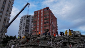 People and emergency teams search for people in a destroyed building in Adana, Monday, Feb. 6, 2023.  (AP Photo/Khalil Hamra)