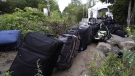 Luggage from migrants fills a pathway at an illegal crossing point from Champlain, N.Y., to Saint-Bernard-de-Lacolle, Que., Monday, Aug. 7, 2017. Quebec's immigration minister says she's surprised by reports that the City of New York is helping to provide free bus tickets to migrants heading north to claim asylum in Canada. THE CANADIAN PRESS/AP Photo/Charles Krupa