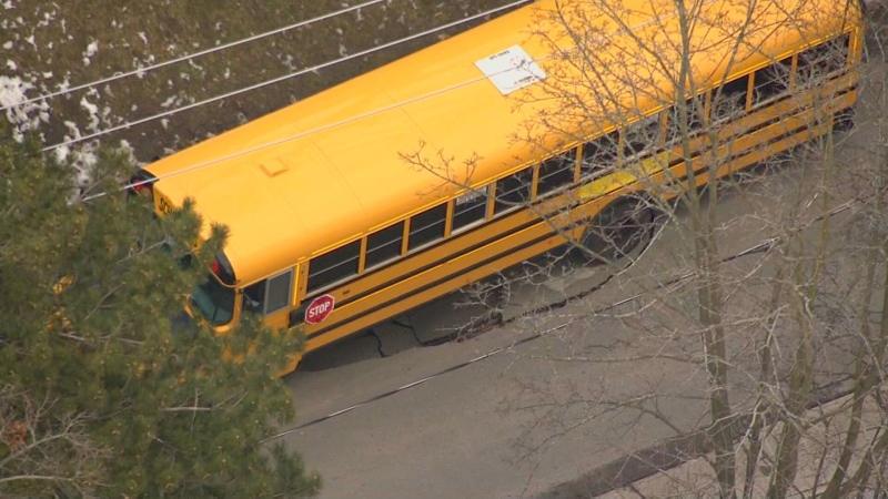 A school bus sits in a sink hole on Balsam Avenue in The Beaches Monday February 6, 2023. 