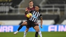 Newcastle's Christian Atsu, right, challenges for the ball with Leeds United's Diego Llorente during the English Premier League soccer match between Newcastle United and Leeds United at St. James' Park in Newcastle, England, Tuesday, Jan. 26, 2021.(Stu Forster/Pool via AP)