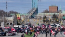 Police officers hold a line as protesters support the truckers as the police enforce an injunction against their demonstration, which has blocked traffic across the Ambassador Bridge by protesters against COVID-19 restrictions, in Windsor, Ont., Saturday, Feb. 12, 2022. THE CANADIAN PRESS/Nathan Denette