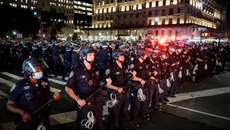 New York Police Department officers stand in formation after arresting multiple protesters marching after curfew on Fifth Avenue, Thursday, June 4, 2020, in New York. (AP Photo/John Minchillo)