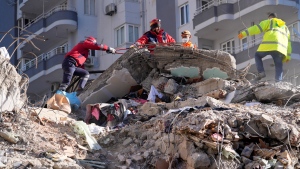 Emergency teams search for people in the rubble of a destroyed building in Adana, southern Turkiye, Feb. 7, 2023. (AP Photo/Hussein Malla)