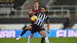 Christian Atsu, right, challenges for the ball with Leeds United's Diego Llorente during the English Premier League soccer match between Newcastle United and Leeds United at St. James' Park in Newcastle, England, Tuesday, Jan. 26, 2021.(Stu Forster/Pool via AP)