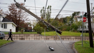 A snapped power pole hangs over a street in New Glasgow, N.S. on Wednesday, September 28, 2022 following significant damage brought by post tropical storm Fiona. THE CANADIAN PRESS/Darren Calabrese 