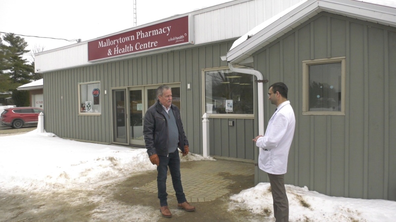 Front of Yonge Township Mayor Roger Haley (left) speaks with pharmacist owner Mayur Vadher in front of the closed walk-in clinic in Mallorytown, Ont. (Nate Vandermeer/CTV News Ottawa)