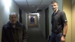 Edgar Calderon and Peter Davey stand in a hallway surrounded by various incomplete work in their apartment building. (Carla Shynkaruk/CTV News)