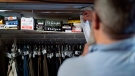 Mark Carlson pulls back a curtain to his wardrobe where he keeps ammunition in his home in Hammond, Wis., Wednesday, Sept. 28, 2022. (AP Photo/David Goldman)