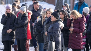 Parents wait for news after a bus crashed into a daycare centre in Laval, Que., on Wednesday, February 8, 2023. THE CANADIAN PRESS/Ryan Remiorz