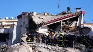 A member of rescue team asking people to be silent for them to hear the people under the debris of a collapsed building, in Ghaziantep, southern Turkiye, Wednesday, Feb 8, 2023.