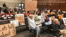Activists hold signs addressing the Tyre Nichols case at a Memphis City Council meeting, Tuesday, Feb. 7, 2023, in Memphis, Tenn. (AP Photo/Adrian Sainz) 