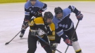 A Fellowes High School hockey player and an Ontario Provincial Police officer going shoulder-to-shoulder at a community hockey game in Pembroke, Ont. (Dylan Dyson/CTV News Ottawa)