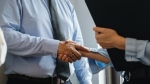 A man and woman are seen shaking hands in an office. (Sora Shimazaki / Pexels.com)