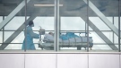 A health-care worker pushes a patient across a connecting bridge at a hospital in Montreal, Thursday, July 14, 2022. THE CANADIAN PRESS/Graham Hughes