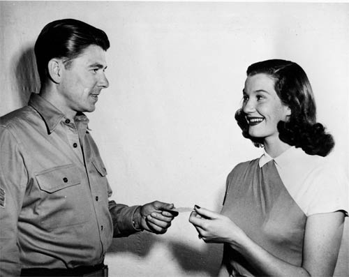 In this March 30, 1947 picture, Lois Maxwell, 20-year-old Canadian-born actress, receives her Screen Actors Guild member card from the new president of the guild, actor Ronald Reagan, in Hollywood, Calif. (AP Photo)