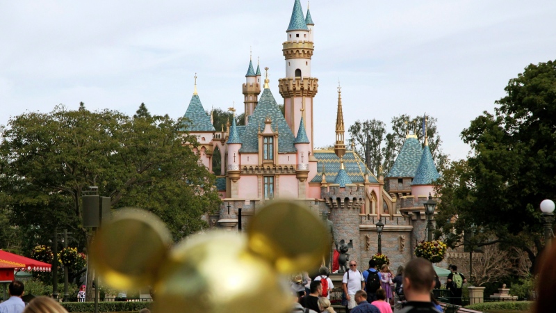 In this Jan. 22, 2015, file photo, visitors walk toward Sleeping Beauty's Castle in the background at Disneyland Resort in Anaheim, Calif. (AP Photo/Jae C. Hong, File)