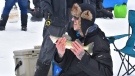 A man catches a fish while competing in the Grand Marais Ice Fishing Derby on March 4, 2023. (Source: John Schneider)