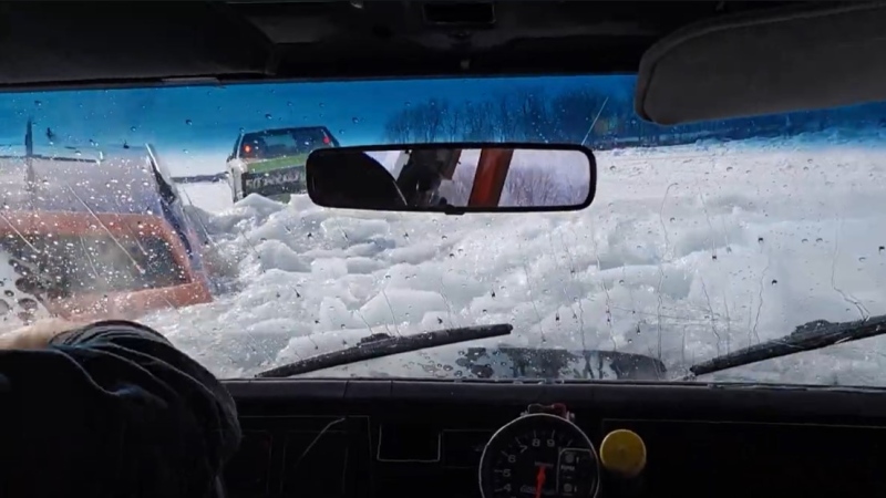 A screenshot of a YouTube video showing two cars going under the ice during the Kahnawake Ice Racing Series. (Source: YouTube/Pat Renaud)