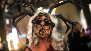 A woman is dressed up in a scary spider costume to participate in the annual Zombie Walk and Halloween Parade in Essen, Germany, Monday, Oct. 31, 2022. (AP Photo/Martin Meissner)