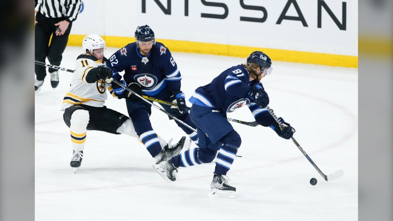 Winnipeg Jets' Nino Niederreiter (62) and Boston Bruins' Trent Frederic (11) collide as Kyle Connor (81) breaks away with the loose puck during third period NHL action in Winnipeg, Thursday, March 16, 2023. THE CANADIAN PRESS/John Woods
