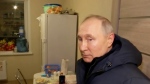 In this photo taken from video released by Russian TV Pool on Sunday, March 19, 2023, Russian President Vladimir Putin listens to local residents at their new flat during his visit to Mariupol in Russian-controlled Donetsk region, Ukraine. Putin has traveled to Crimea to mark the ninth anniversary of the Black Sea peninsula's annexation from Ukraine. (Pool Photo via AP)