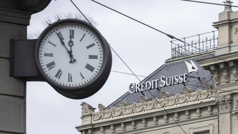 Five to twelve 'fuenf vor zwoelf' is written on a clock next to a logo of the Swiss bank Credit Suisse, in Zurich, Switzerland, Monday, March 20, 2023. (Ennio Leanza/Keystone via AP) 