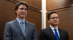 Prime Minister Justin Trudeau stands with Conservative leader Pierre Poilievre as he waits to speak at a Tamil heritage month reception, Monday, January 30, 2023 in Ottawa. THE CANADIAN PRESS/Adrian Wyld