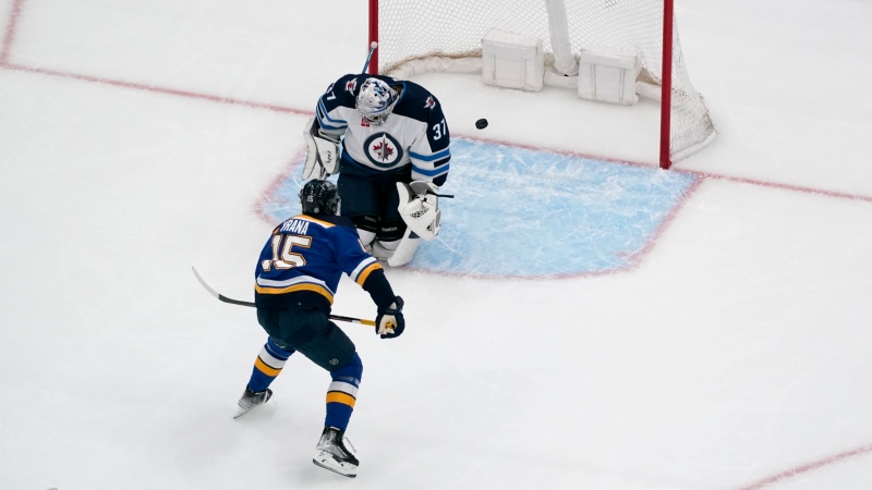 St. Louis Blues' Jakub Vrana (15) scores past Winnipeg Jets goaltender Connor Hellebuyck (37) during the third period of an NHL hockey game Sunday, March 19, 2023, in St. Louis. (AP Photo/Jeff Roberson)