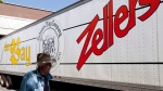 A man walks past a Zellers transport truck outside a Zellers store in Lynn Valley in North Vancouver, B.C., July, 26, 2012. THE CANADIAN PRESS/Jonathan Hayward