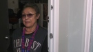 Darlene Blyan stands at her door which has several bullet holes from last week's shooting that killed two Edmonton police constables (CTV News Edmonton).