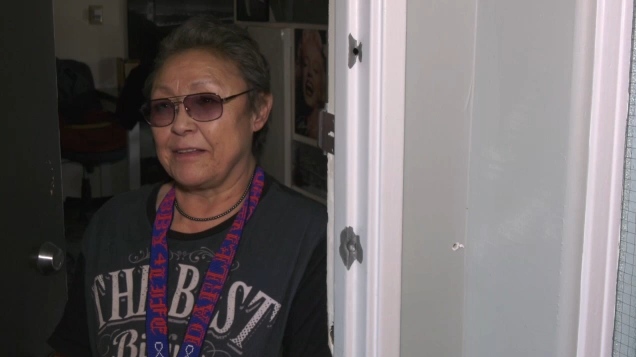 Darlene Blyan stands at her door which has several bullet holes from last week's shooting that killed two Edmonton police constables (CTV News Edmonton).
