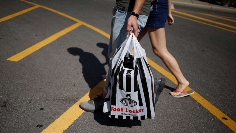 Foot Locker is planning to shut 400 stores by 2026 as it strives to become more relevant to younger shoppers and pictured, a pedestrian carries a Foot Locker Inc. bag at the Easton Town Center shopping mall in Columbus, OH, on Aug. 23, 2016. (Luke Sharrett/Bloomberg/Getty Images)
