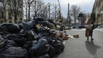 Walking past an uncollected garbage pile in Paris, France, on March 20, 2023. (Aurelien Morissard / AP) 