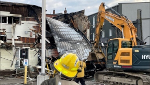 A backhoe had to be brought in after the roof collapsed during a fire in Aylmer, Ont. on March 21, 2023. (Sean Irvine/CTV News London)
