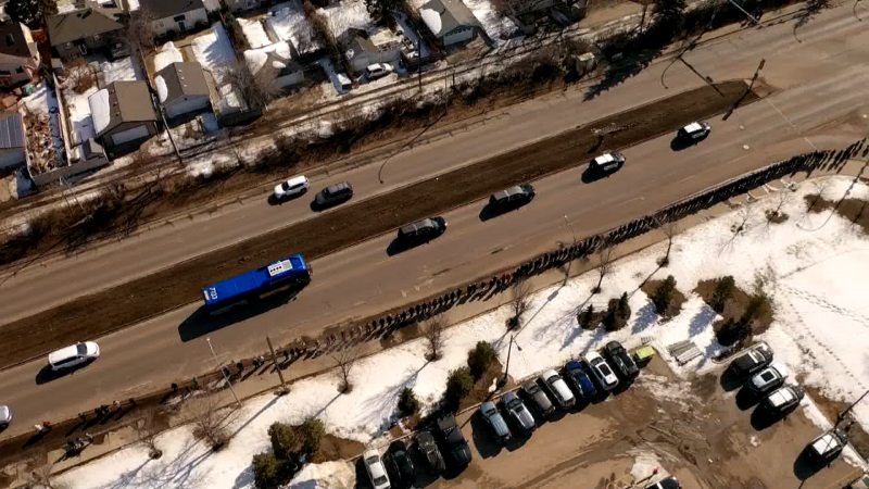 Dozens of Edmontonians lined up on the side of the road for the procession that took EPS constables Brett Ryan and Travis Jordan to a funeral home on Tuesday, March 21, 2023. (Cam Wiebe/CTV News Edmonton)