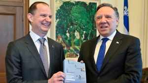 Quebec Finance Minister Eric Girard, left, and Quebec Premier Francois Legault hold a copy of the budget speech, Tuesday, March 21, 2023 at the premier’s office in Quebec City. THE CANADIAN PRESS/Jacques Boissinot