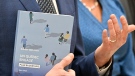 Quebec Finance Minister Eric Girard holds a copy of the provincial budget speech at a news conference on the eve of the budget Monday, March 20, 2023 in Quebec City. Quebec Minister of Families Suzanne Roy, right, looks on. THE CANADIAN PRESS/Jacques Boissinot