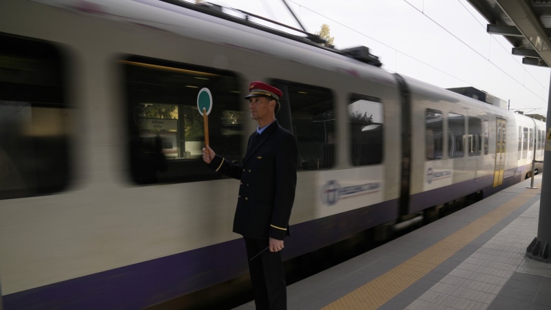A station master uses a signalling disc for the departure of a train at the main station in Athens, Greece, Wednesday, March 22, 2023. (AP Photo/Thanassis Stavrakis)