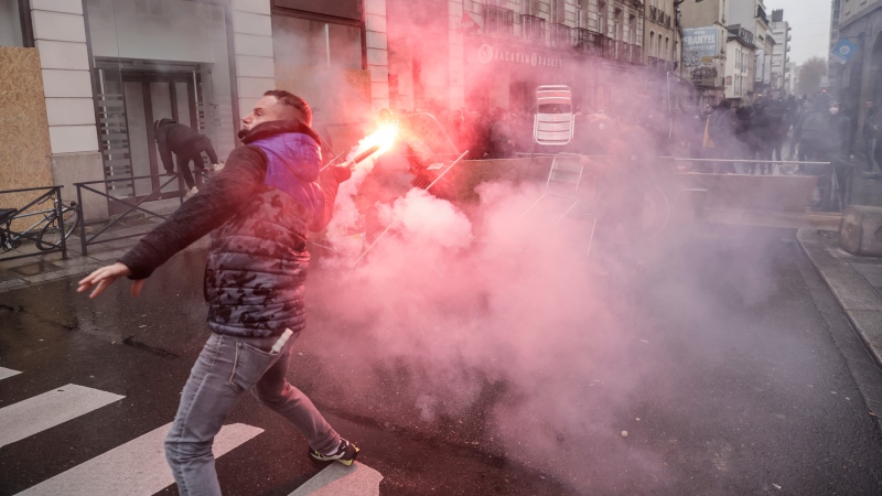 A protester throws a flare towards riot police face during a protest in Rennes, western France, Wednesday, March 22, 2023. (AP Photo/Jeremias Gonzalez) 